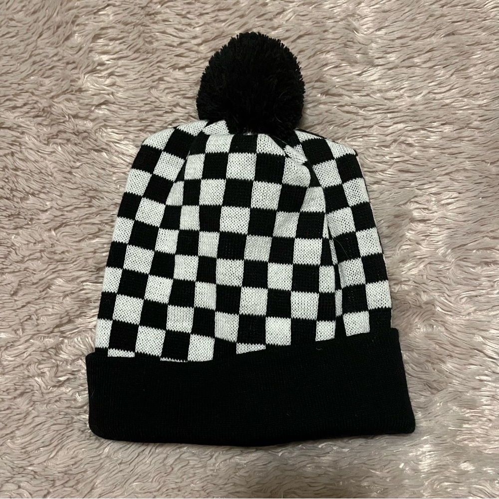 Checkered black and white knit hat with pompon